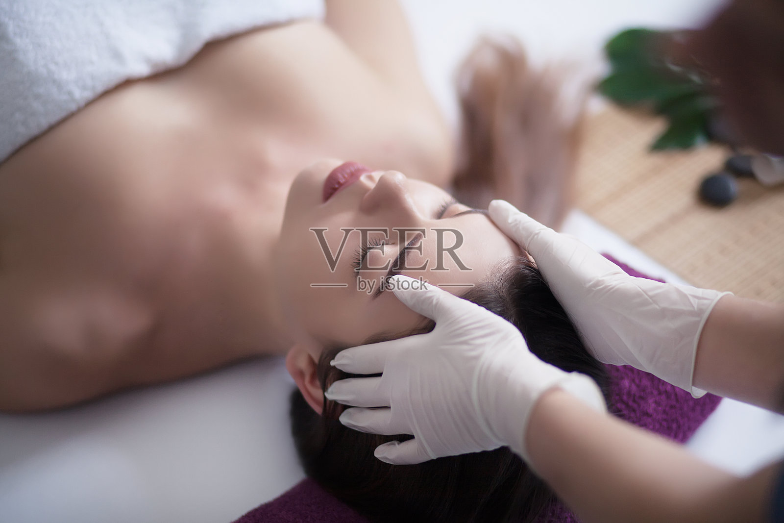 身体保健。水疗身体按摩治疗。有个女人在水疗沙龙按摩照片摄影图片