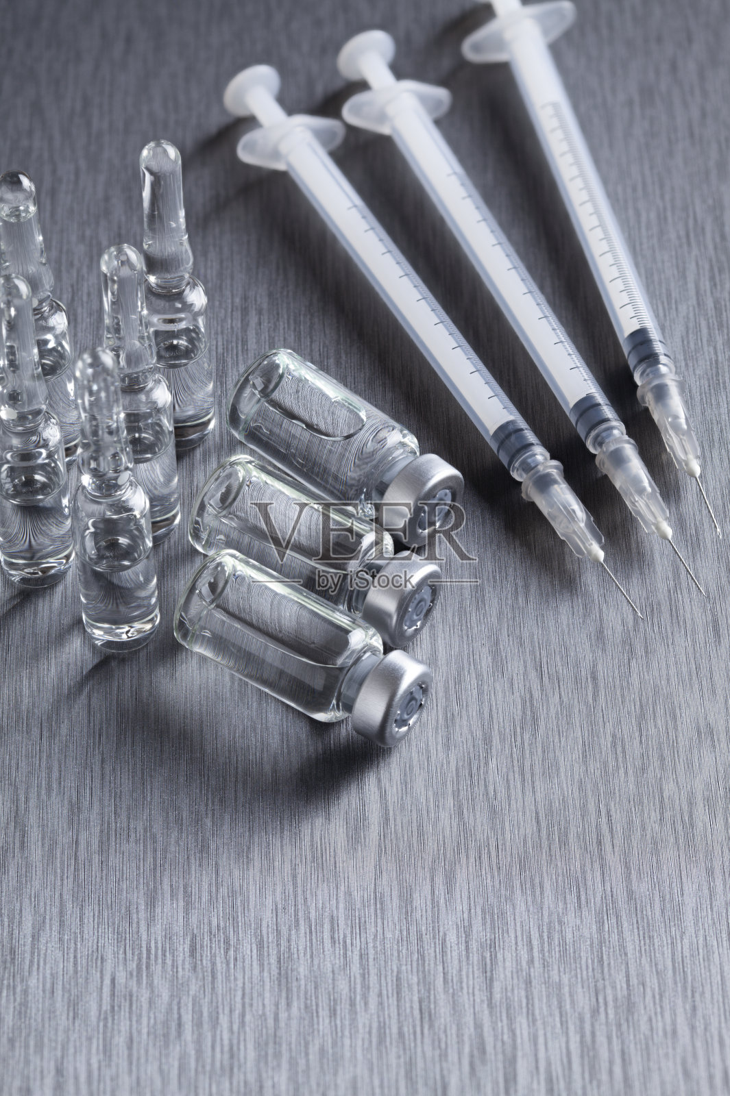 在钢铁背景上的玻璃瓶和胰岛素注射器照片摄影图片