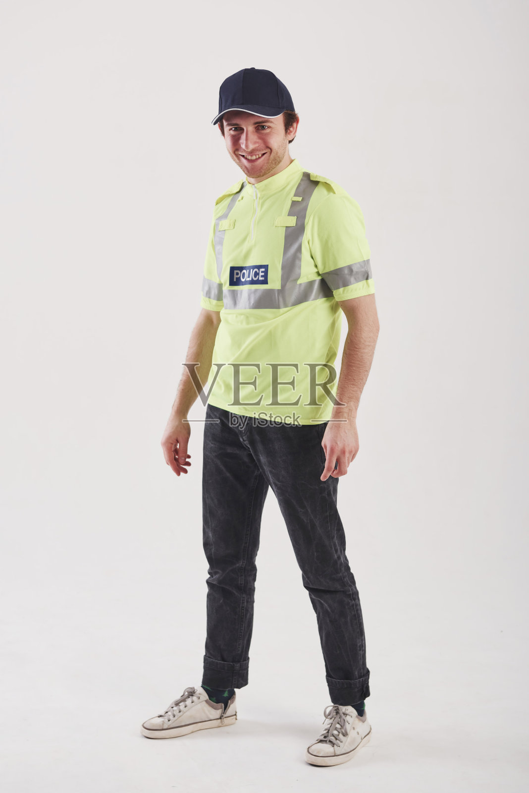 为你的安全。在演播室里，身穿绿色制服的警察站在白色背景下照片摄影图片