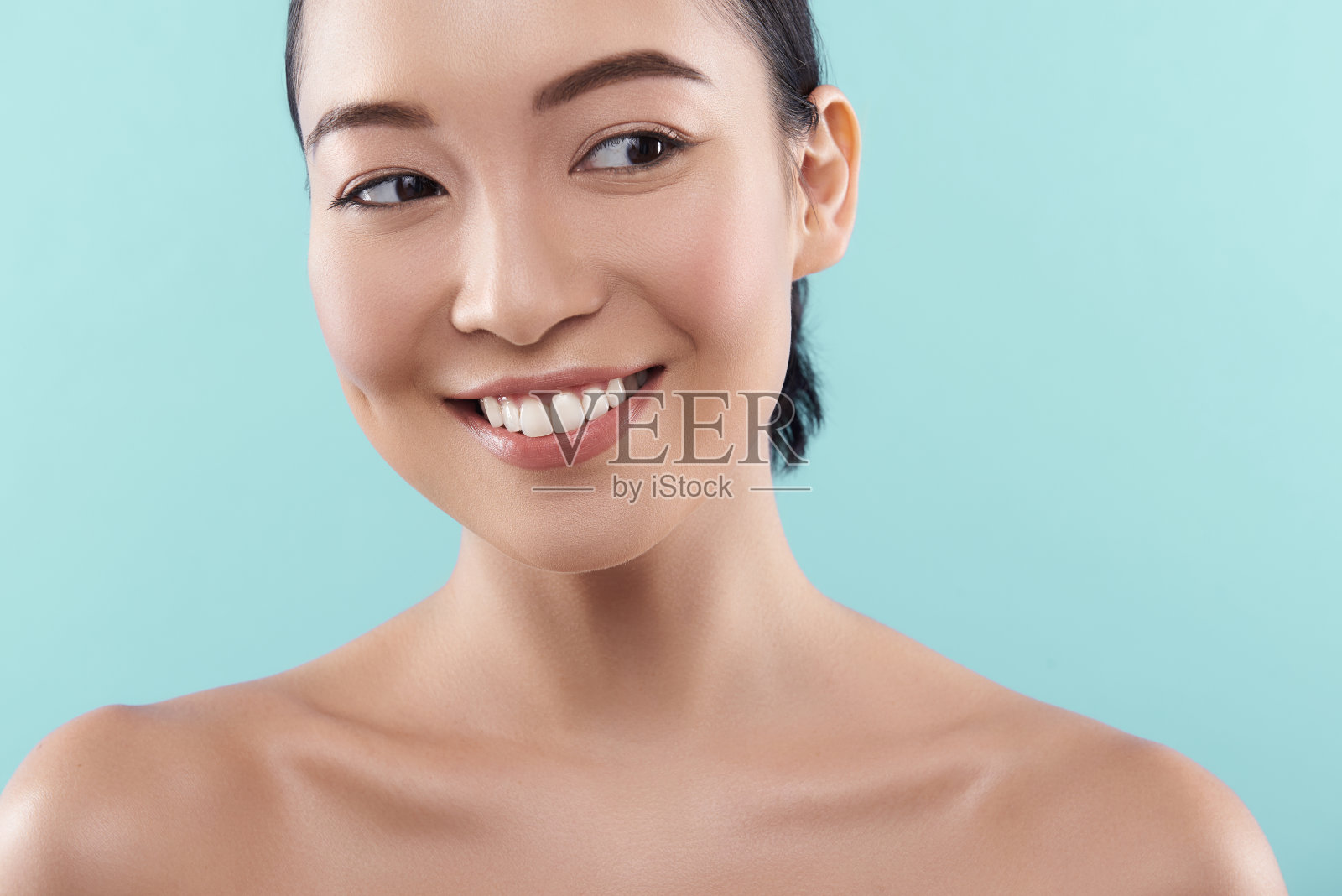 近距离的迷人的亚洲女士看着远离蓝色的背景照片摄影图片