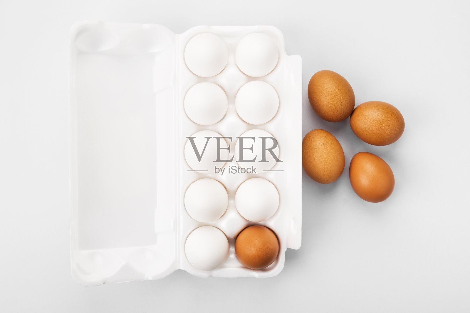 一组白色和棕色的生鸡蛋。多样性、孤立、种族主义、不平等的概念。在灰色背景。俯视图照片摄影图片