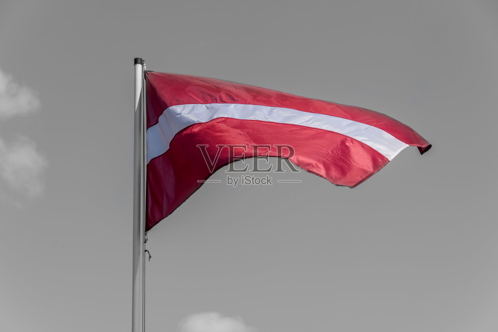 拉脱维亚国旗在一个有风的日子和晴朗的天空照片摄影图片