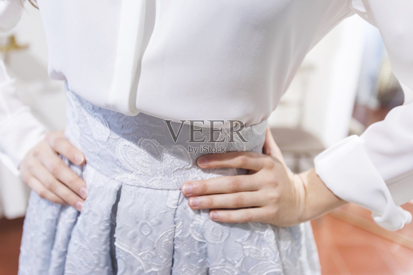 在试衣间里站着的年轻女子的腰部特写照片摄影图片