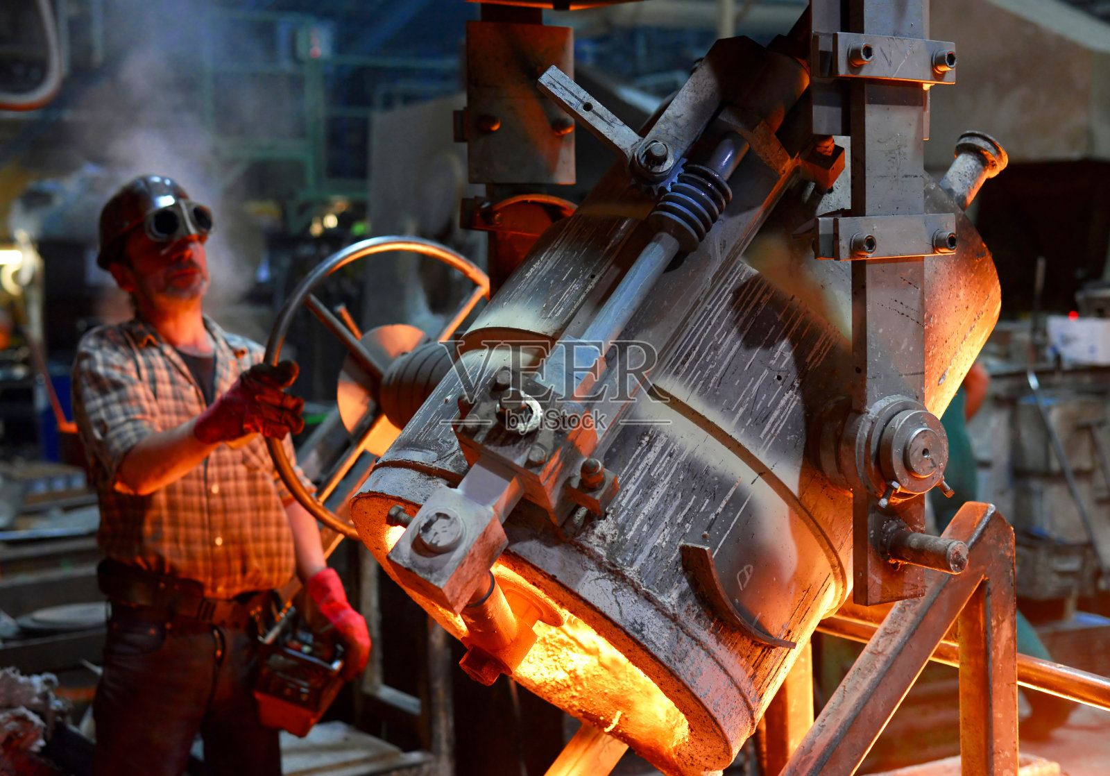 铸造金属工件的工人-工作中的安全与团队合作照片摄影图片