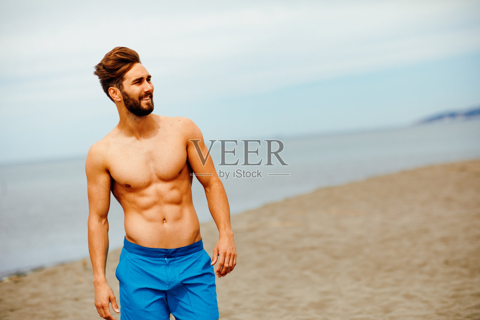 帅哥在沙滩上摆姿势照片摄影图片