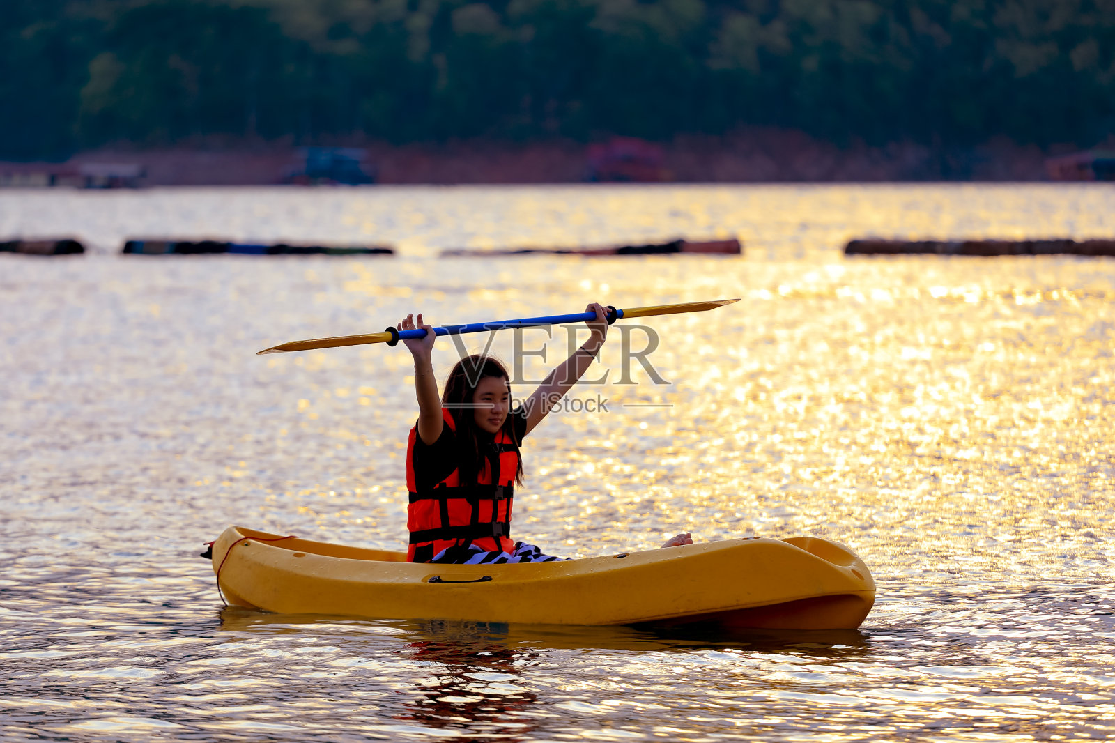 在湖上划皮艇，在山的背后看日落照片摄影图片