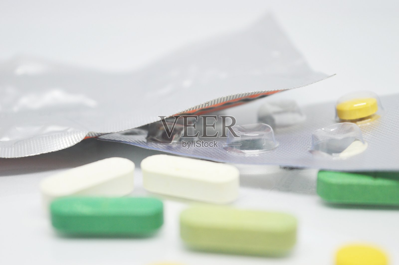 在明亮的背景上分离的胶囊药物照片。照片摄影图片