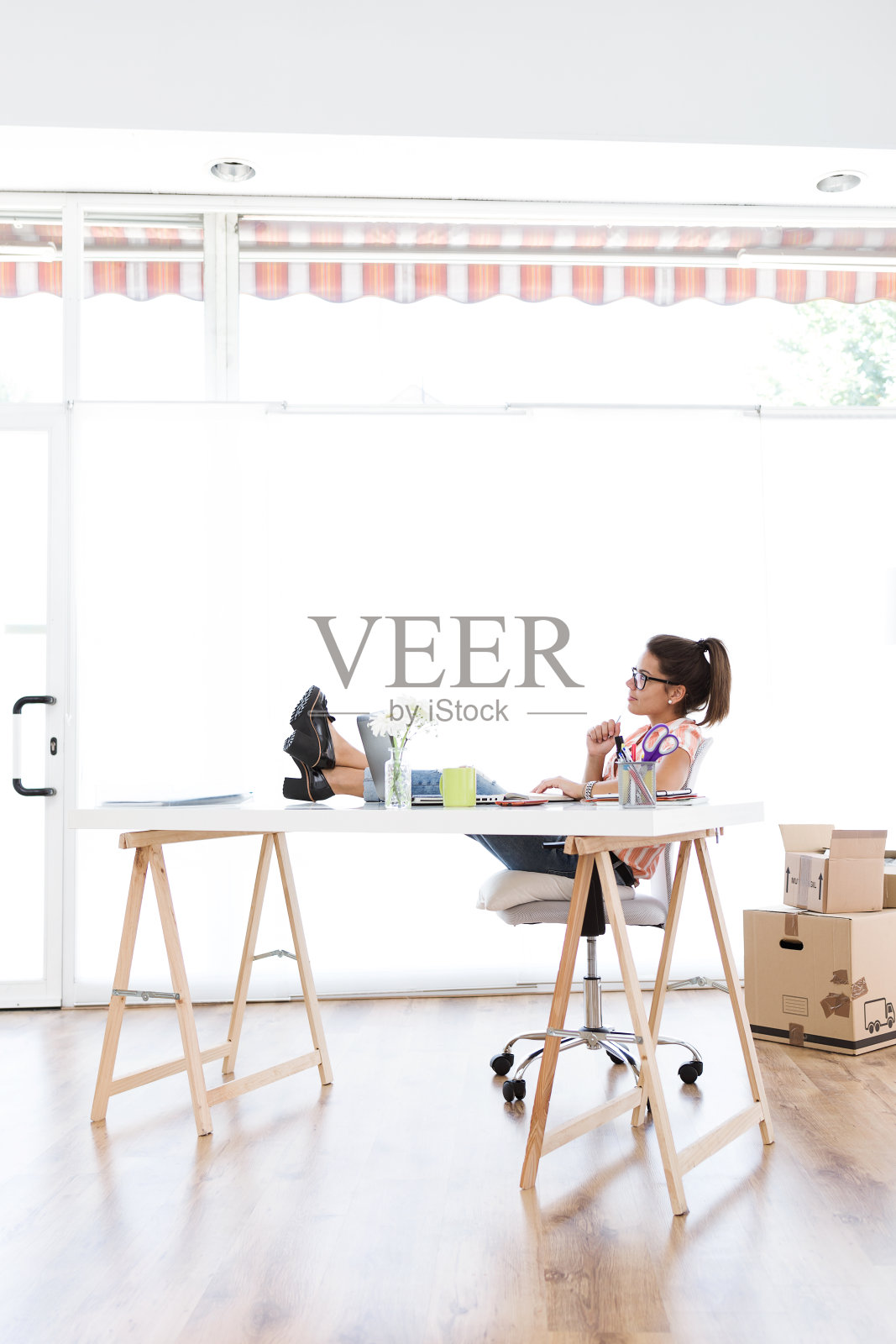 漂亮的年轻女人在她的新办公室工作。照片摄影图片