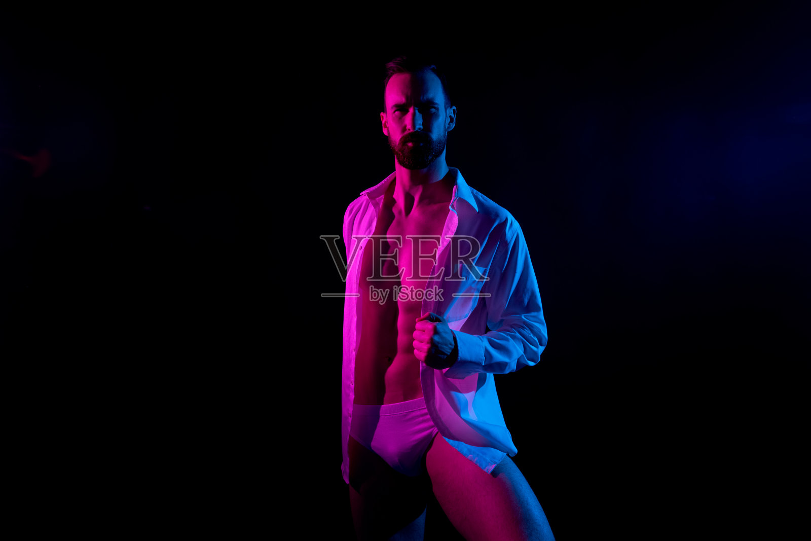 非常有吸引力的男人白色衬衫和内衣在黑色背景和凝胶照明照片摄影图片