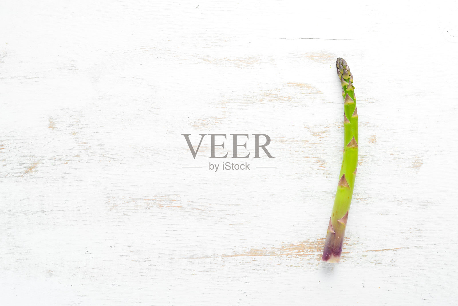 新鲜的绿色芦笋在白色的木制背景上。健康食品。前视图。为你的文本留出空间。照片摄影图片