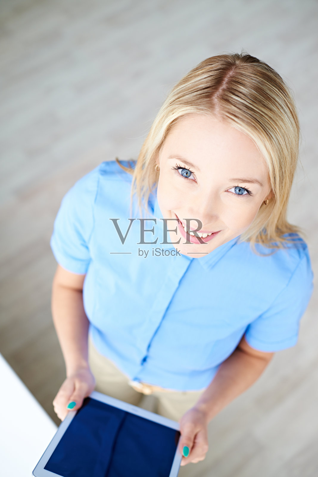 微笑的女人从上面拿着平板电脑照片摄影图片