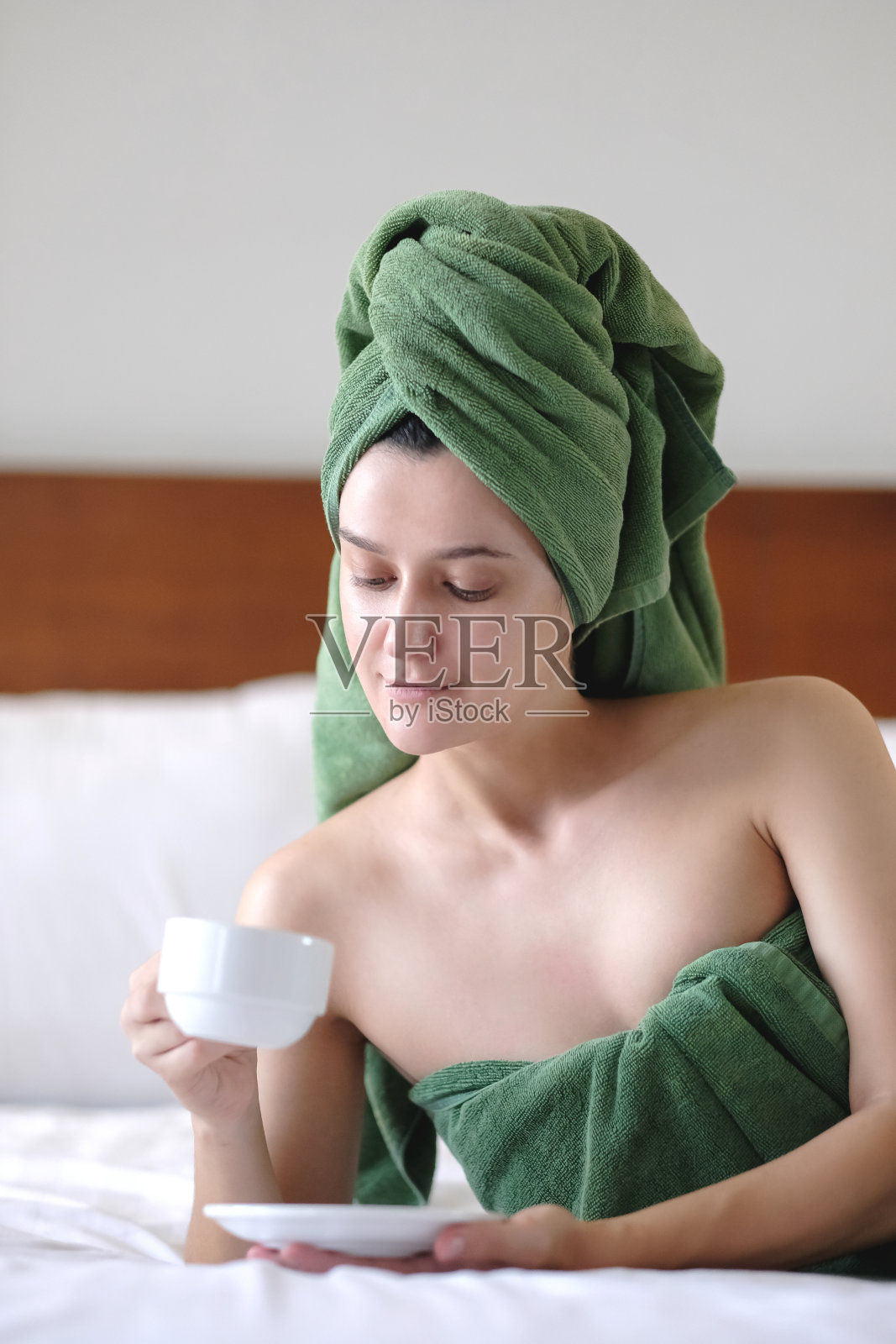 年轻漂亮的女人，早上在床上喝咖啡照片摄影图片