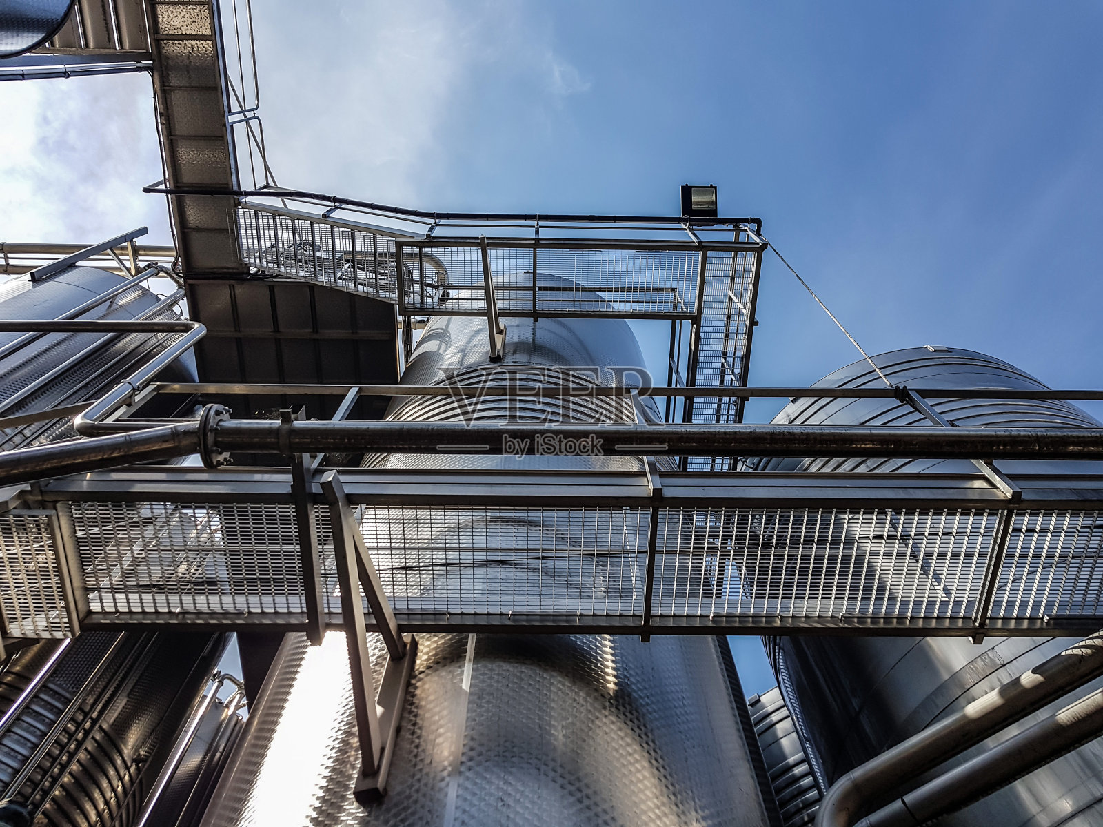 巨大的金属水库之间的金属楼梯和通道照片摄影图片