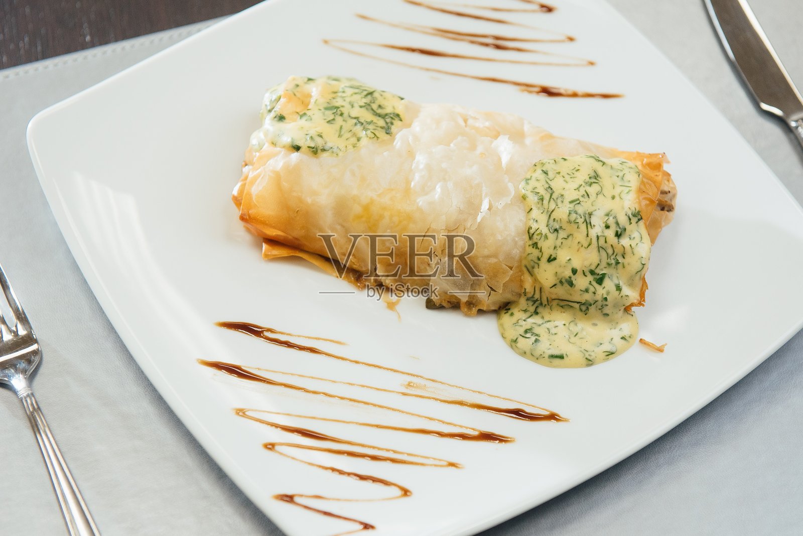 桌上的白盘子里放着加了白酱的炸肉照片摄影图片