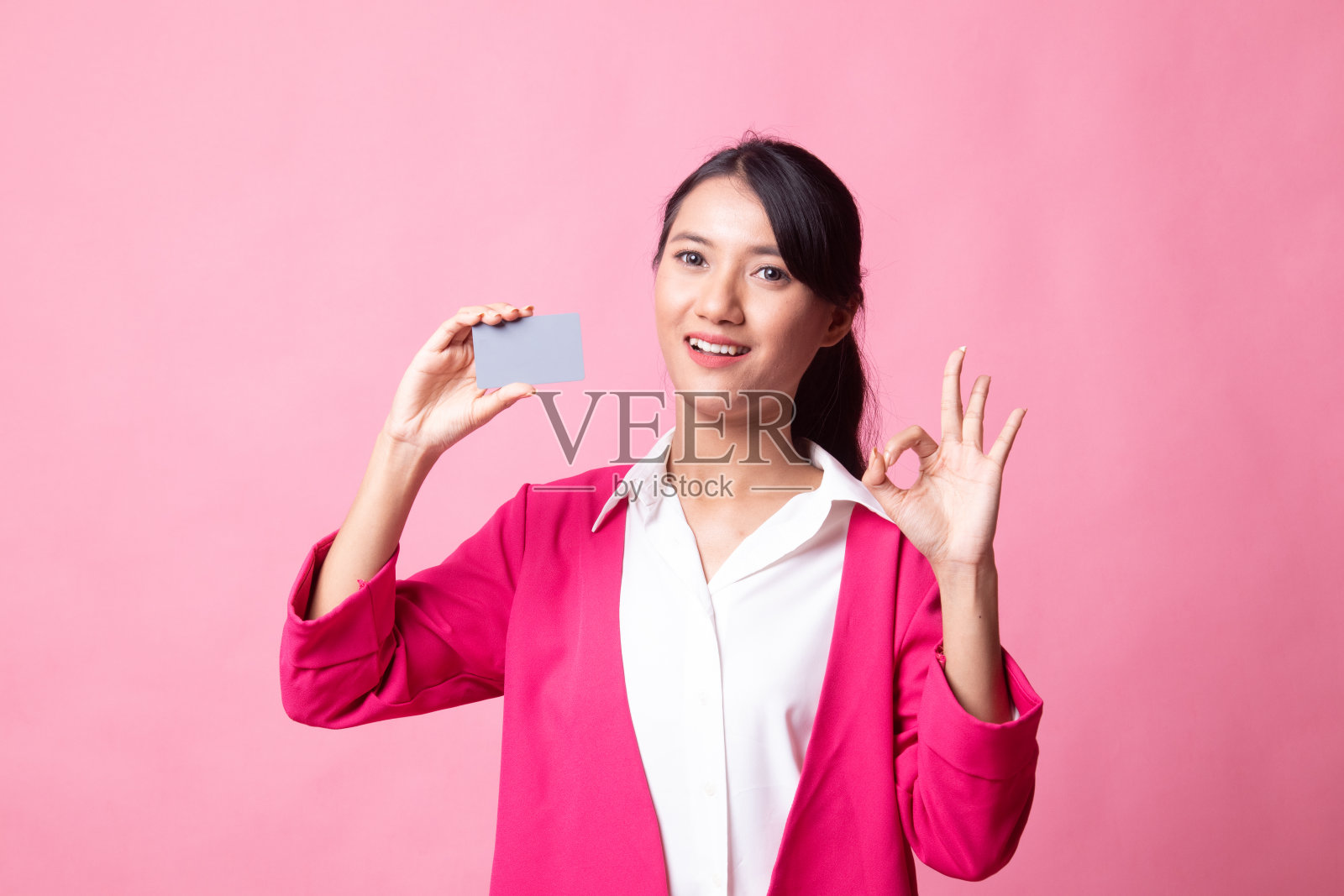 年轻的亚洲女子用一张空白卡片表示OK。照片摄影图片