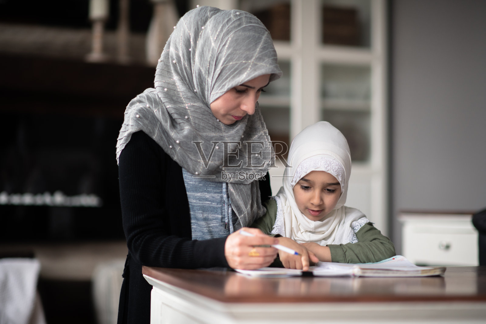 穆斯林母亲和女儿一起做作业照片摄影图片