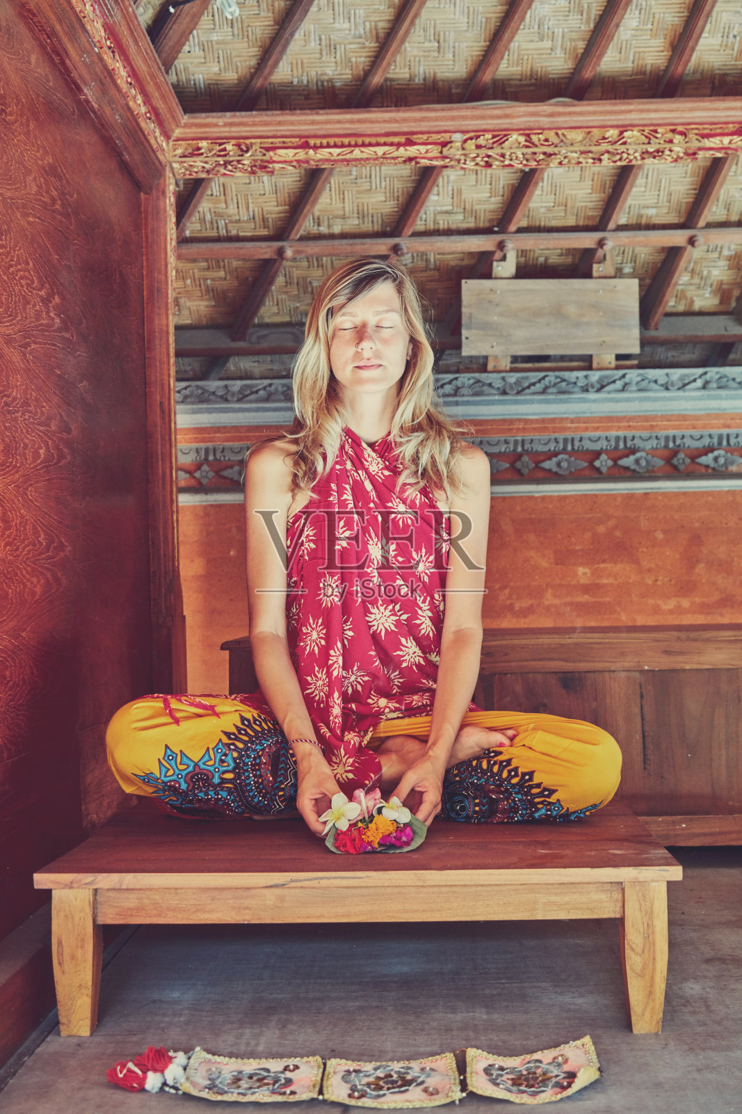 妇女拿着canang纱丽-供神。巴厘岛的传统。照片摄影图片