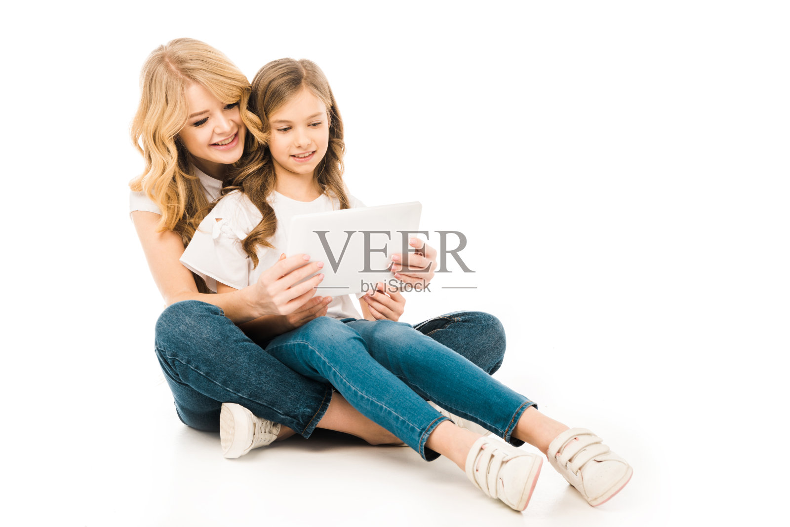 漂亮的妈妈和可爱的孩子坐在地板上，在白色背景上使用笔记本电脑照片摄影图片