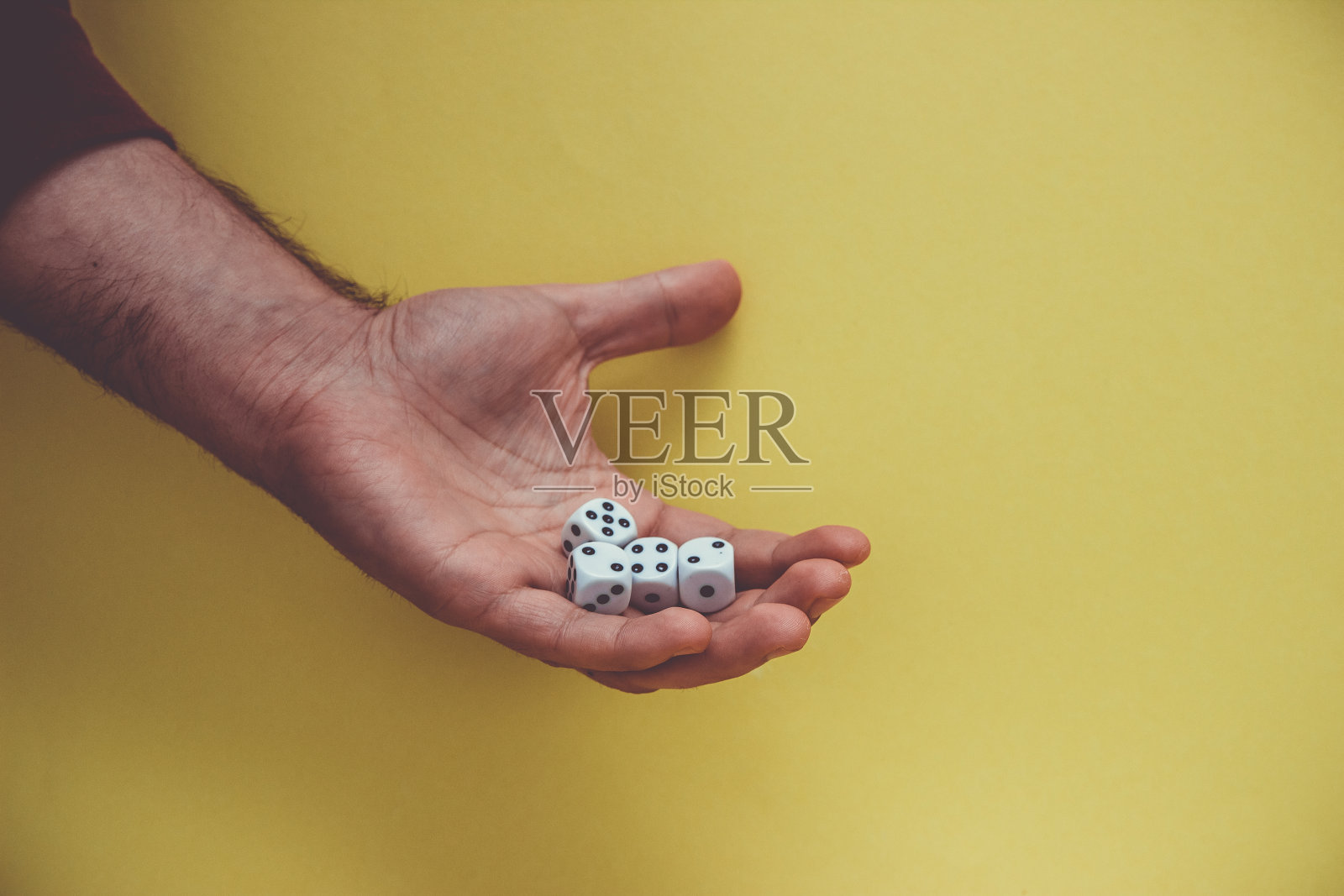 玩骰子在手，孤立在黄色背景。照片摄影图片