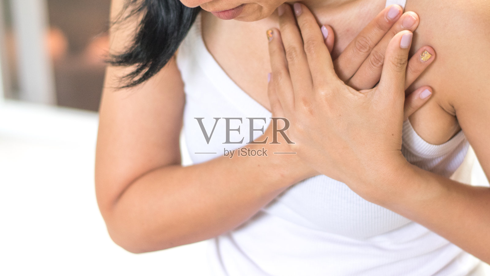 女人的手放在胸前有红斑的地方，就像在忍受胸痛。女性有心脏病发作、肺部问题、心肌炎、心烧灼、肺炎或肺脓肿、肺栓塞的日子照片摄影图片