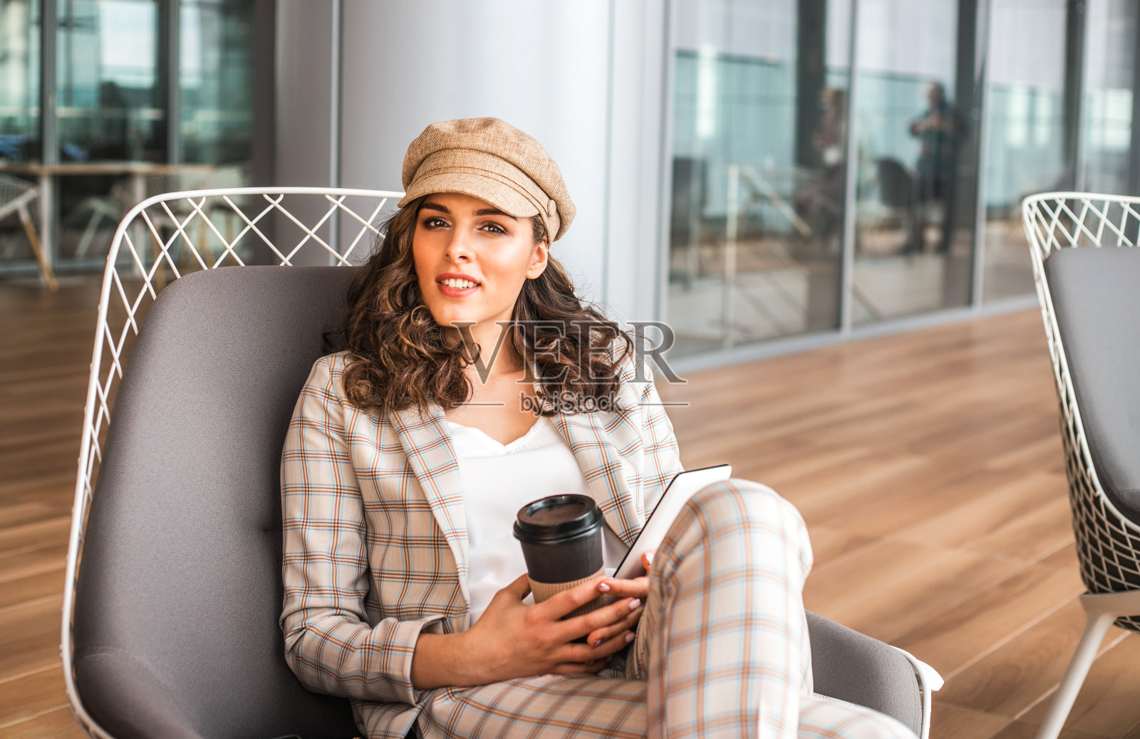 微笑的女人在机场的咖啡馆里喝着咖啡。照片摄影图片