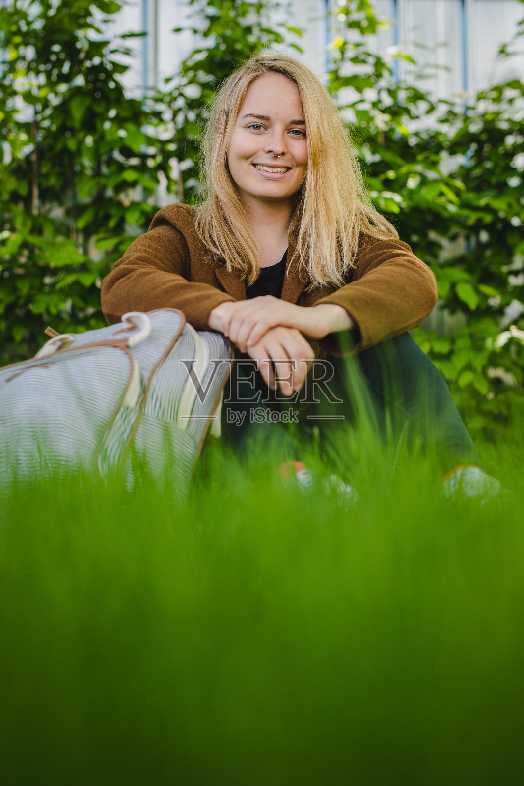 公园里背着背包的年轻时髦女人照片摄影图片