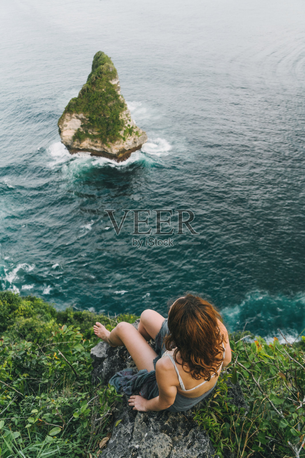 女人坐在努沙佩尼达悬崖上看海的风景照片摄影图片