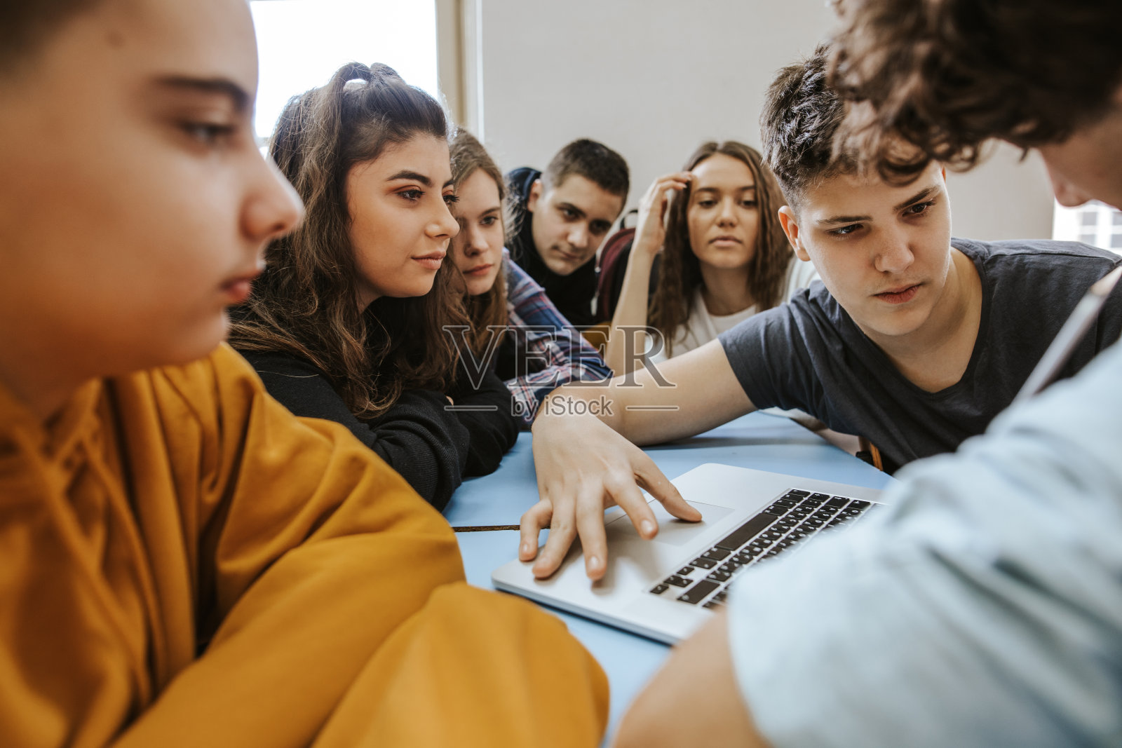 一群青少年在用笔记本电脑聊天和微笑照片摄影图片