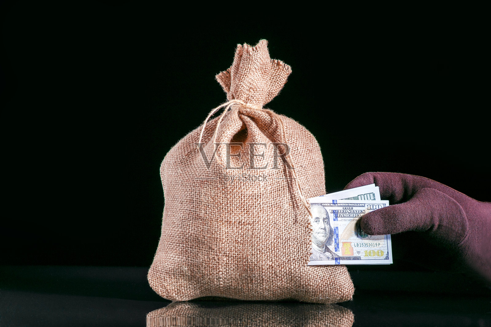 偷钱。钱丢了，袋子破了，钱袋有洞，手抓了一堆美元钞票照片摄影图片