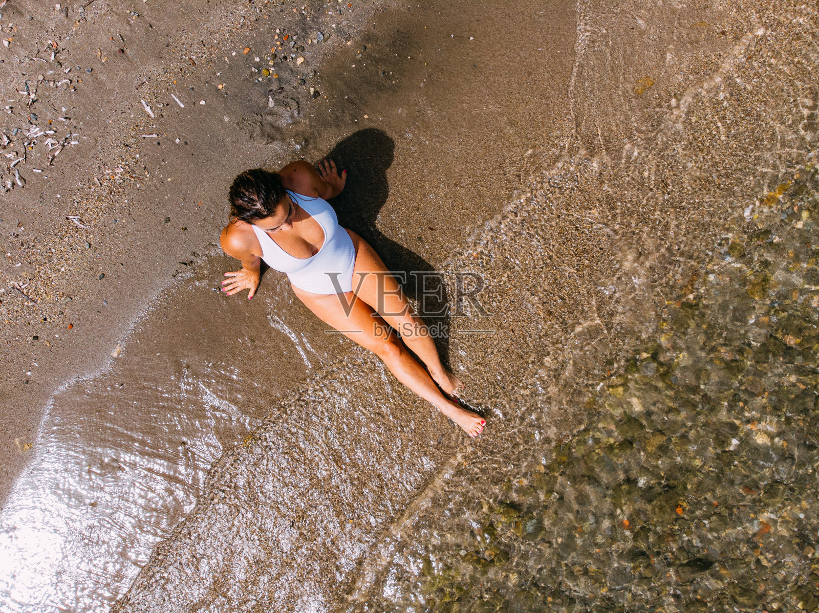 鸟瞰图女人在沙滩上晒太阳照片摄影图片