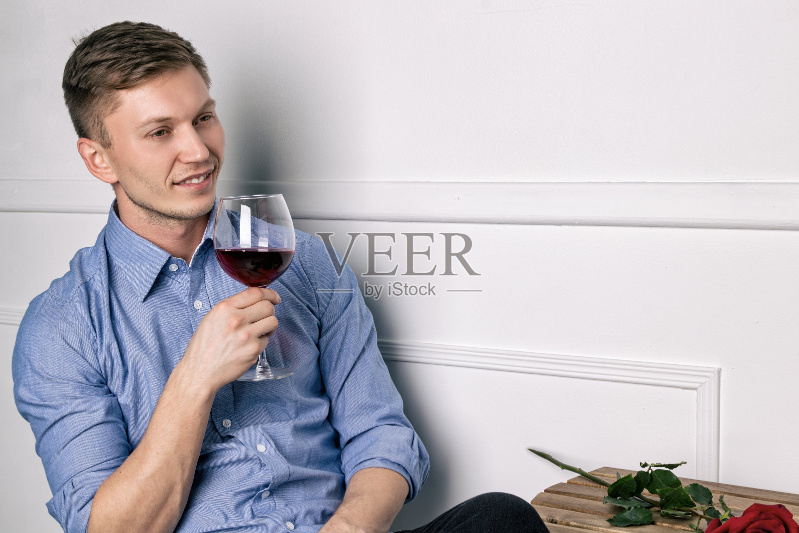 年轻英俊的男子坐在桌旁，在咖啡馆等他的女朋友照片摄影图片