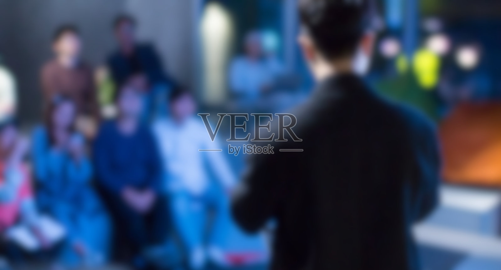 年轻的行政人员正在做模糊的商业演示。有专家演讲的企业研讨会。在演讲中演讲的人。车间领导培训教练。照片摄影图片