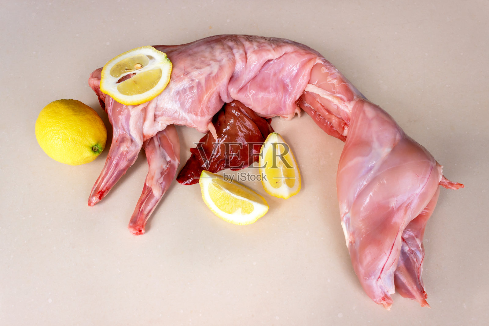 生兔肉配肝脏和多汁的柠檬片。健康饮食的概念照片摄影图片