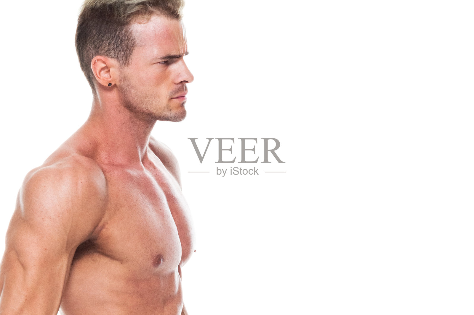 英俊的肌肉男子谁是赤膊和穿着板短裤和弯曲他的肌肉照片摄影图片