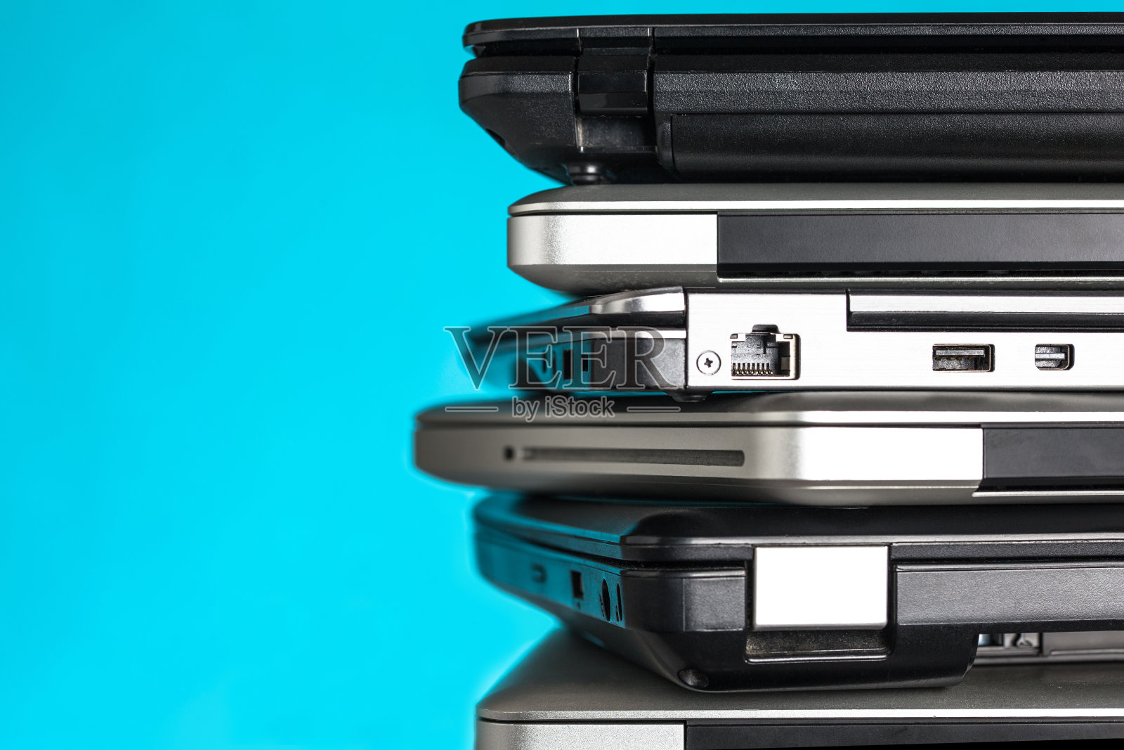 蓝色背景的笔记本电脑/笔记本电脑的堆叠和复制空间照片摄影图片