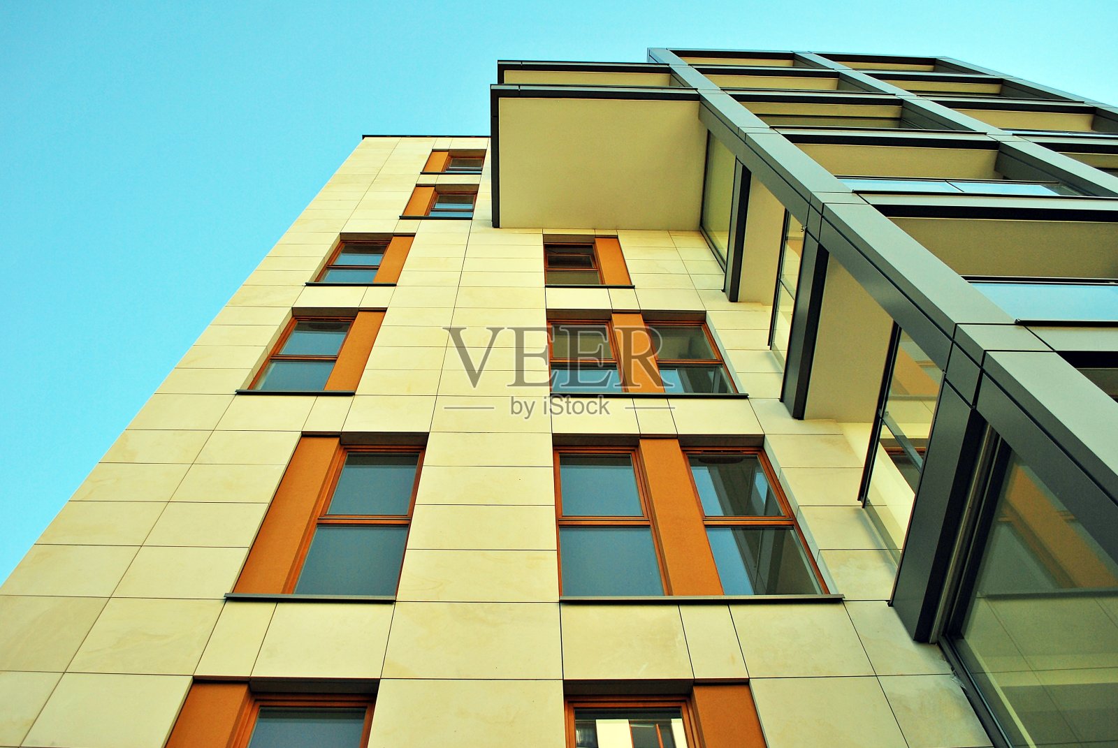现代化的公寓大楼在一个晴朗的日子与蓝天。现代公寓楼的立面照片摄影图片