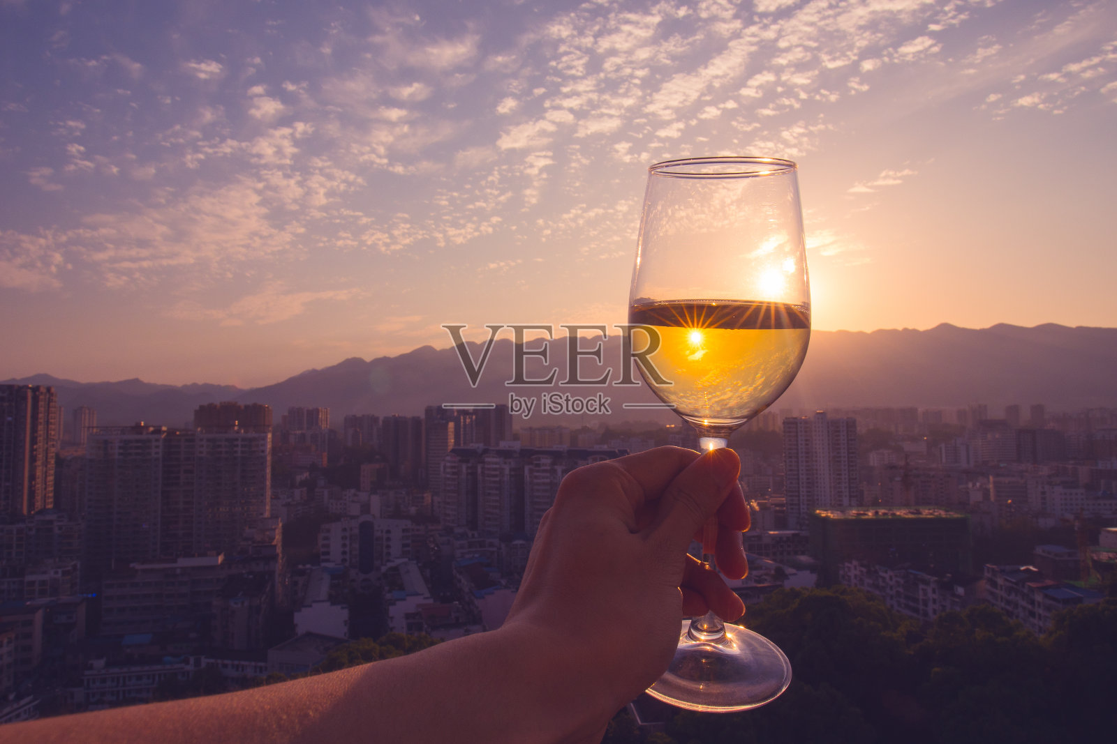 日落时分，手握香槟照片摄影图片