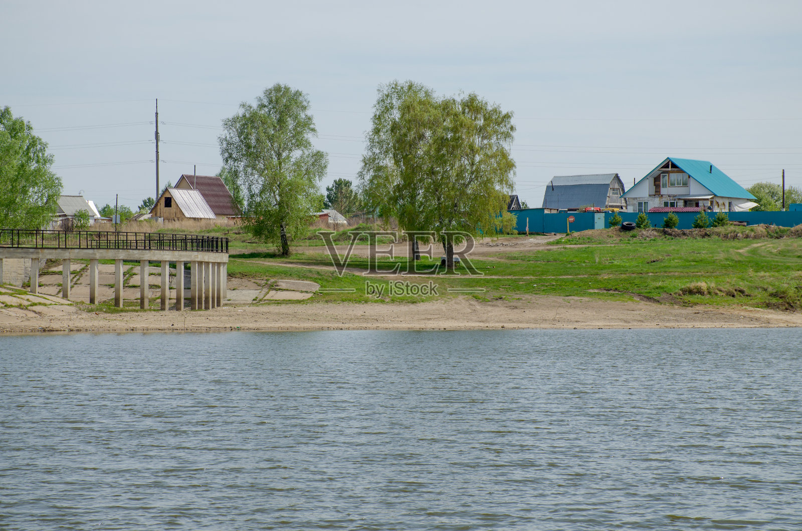 以俄罗斯西伯利亚春天的村庄为背景的湖泊景观照片摄影图片