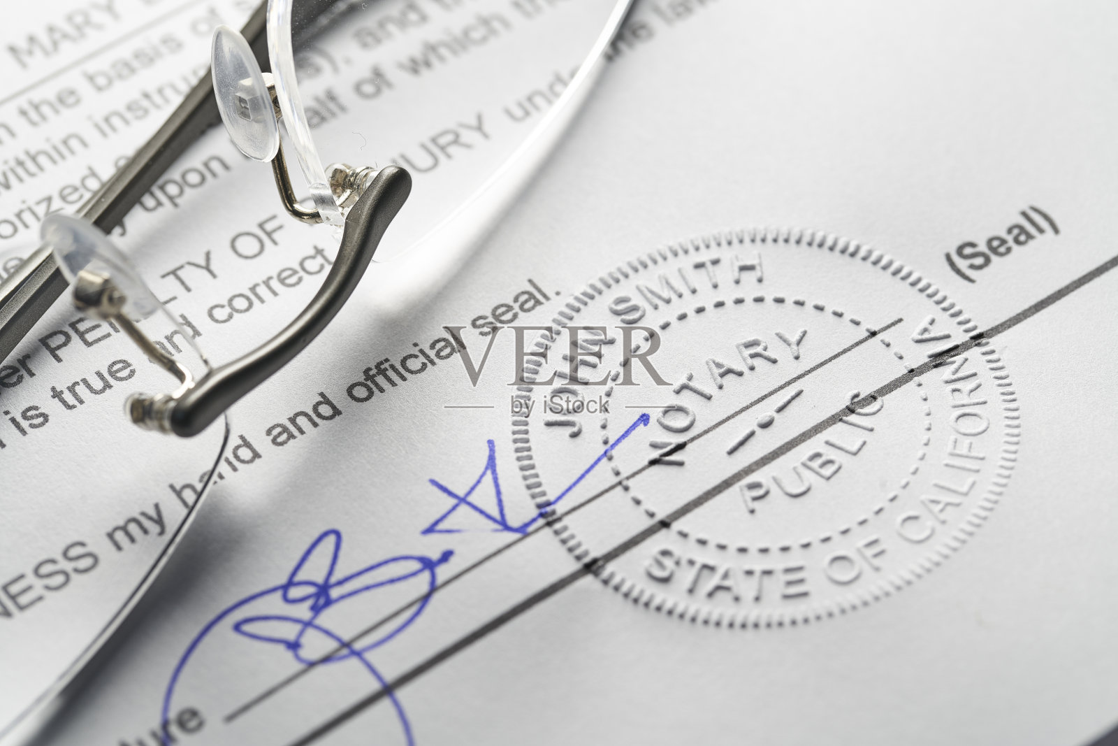 公证人:用笔和眼镜在文件上压印的印章照片摄影图片