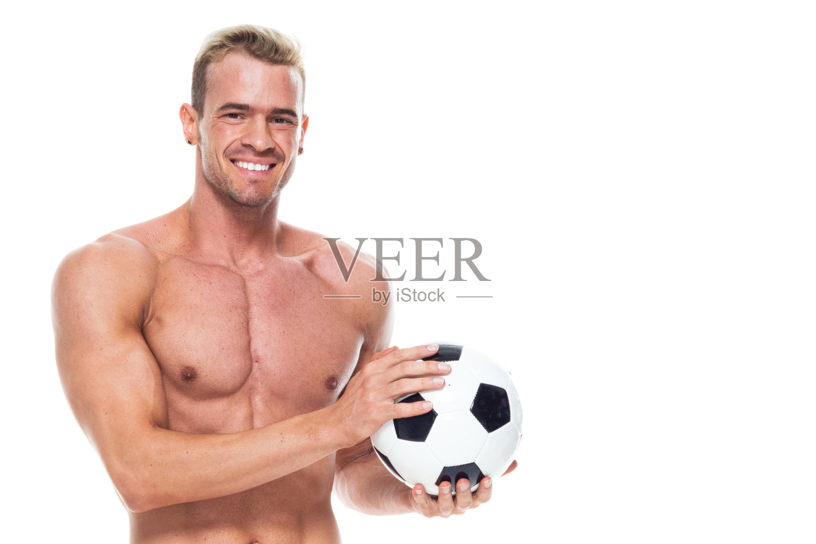 帅气的男人，他赤膊上阵，穿着短裤，还有一个足球照片摄影图片