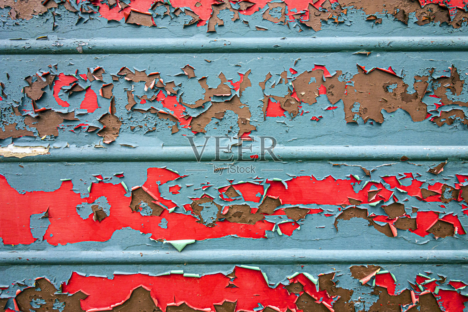 一扇非常风化的金属车库门，背景漆已磨掉照片摄影图片