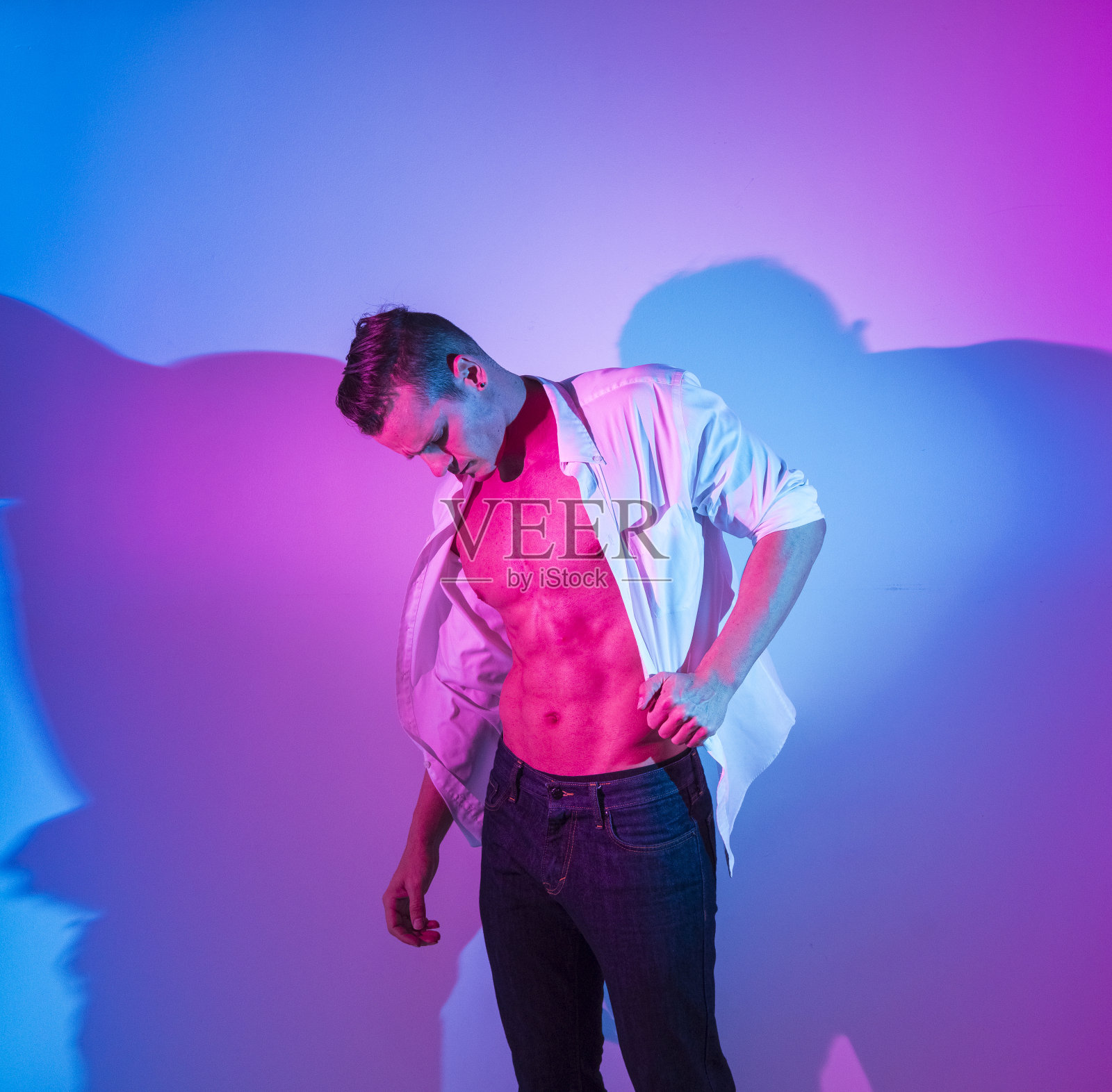 英俊的男人感觉性感和穿着一件解开的白衬衫照片摄影图片