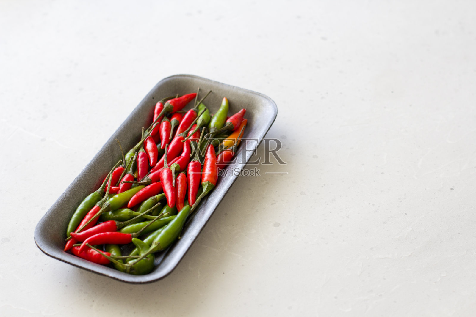 红辣椒在白色和浅灰色现代背景或白色桌子。很多红辣椒。青辣椒。为你的文本复制空间。平躺，俯视图照片摄影图片