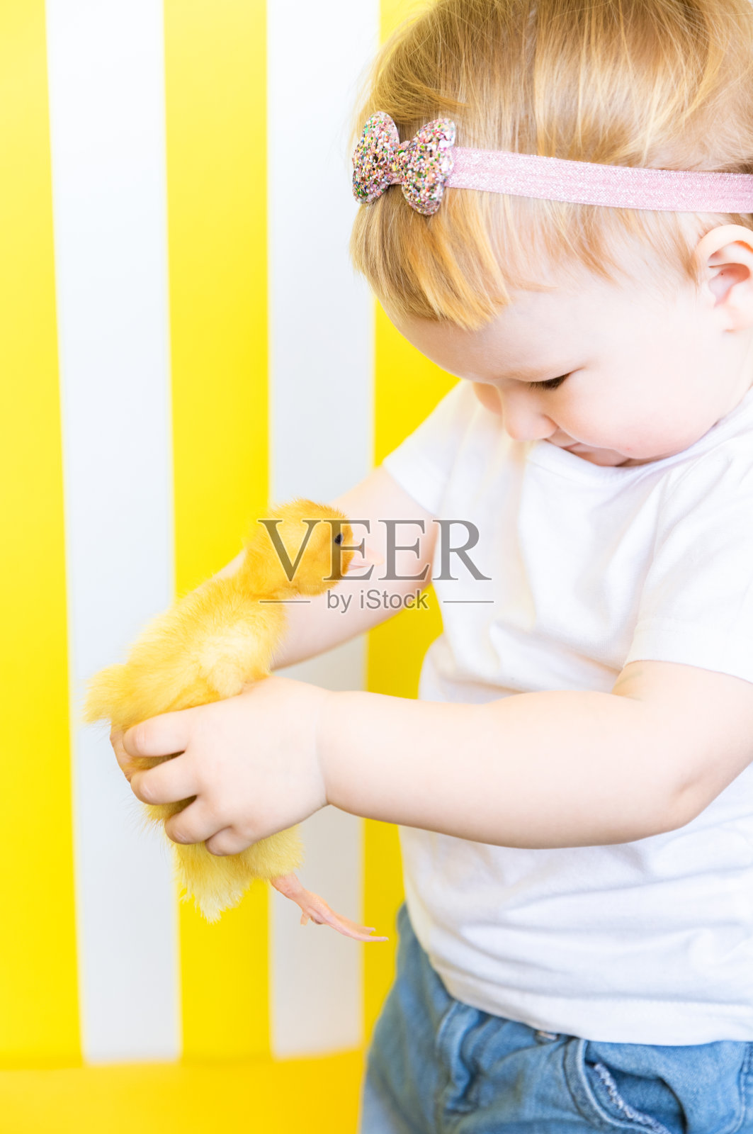 一个女孩和一个鸭子小鸡的明亮肖像。儿童对动物的爱照片摄影图片