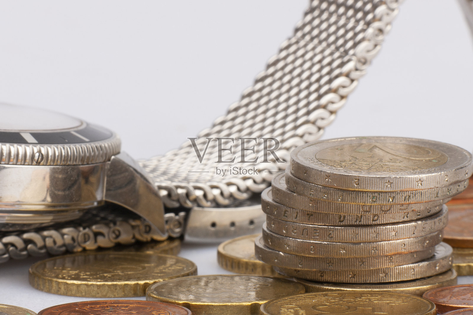 一堆孤立在白色背景上的欧元硬币。全球化、时代和商业理念。古董圆钟上堆叠的硬币有限的景深照片摄影图片