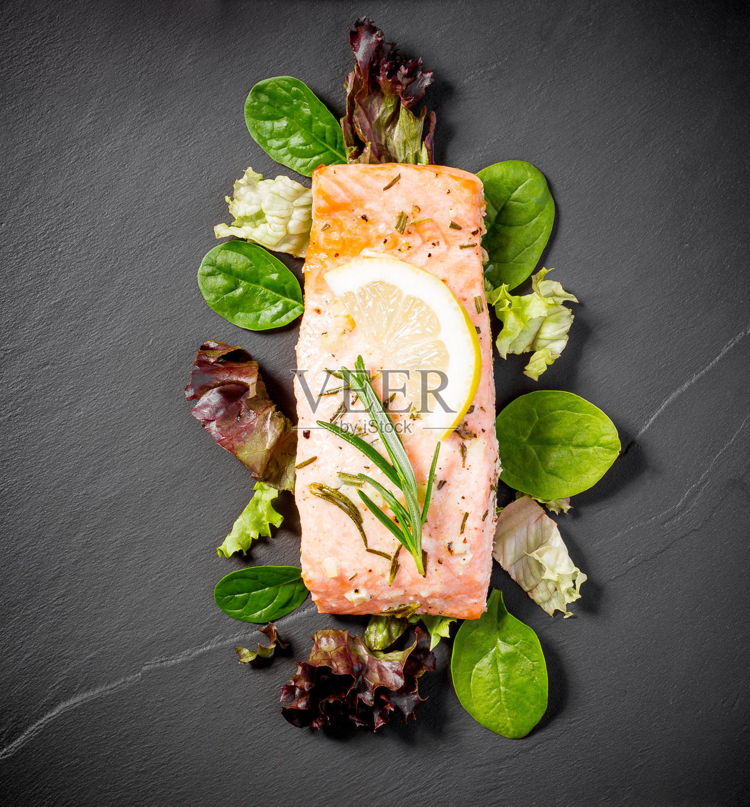 烤三文鱼片配沙拉，放在黑板板上照片摄影图片