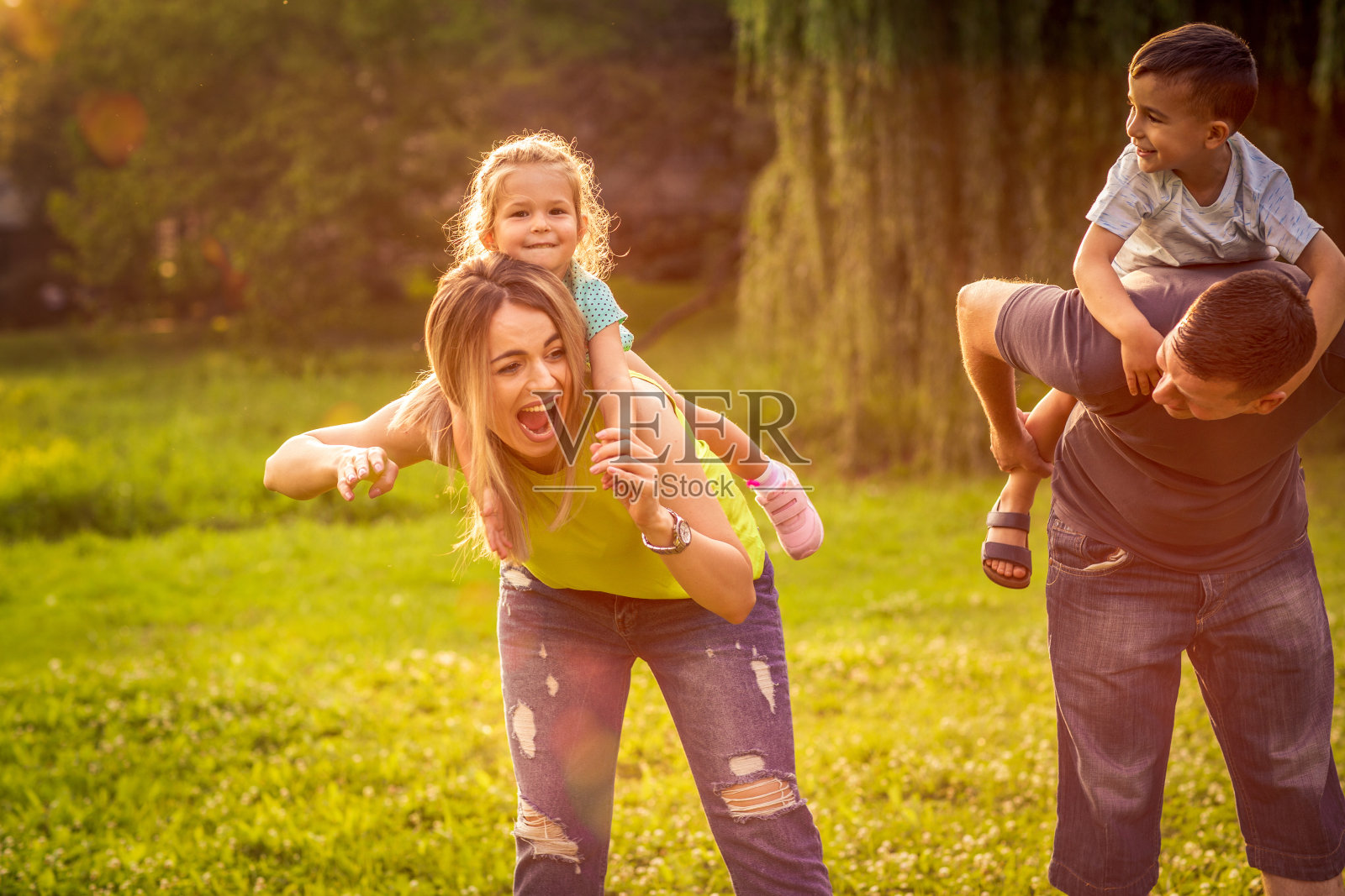 欢乐时光：年轻夫妇与孩子在美丽的户外公园玩耍照片摄影图片