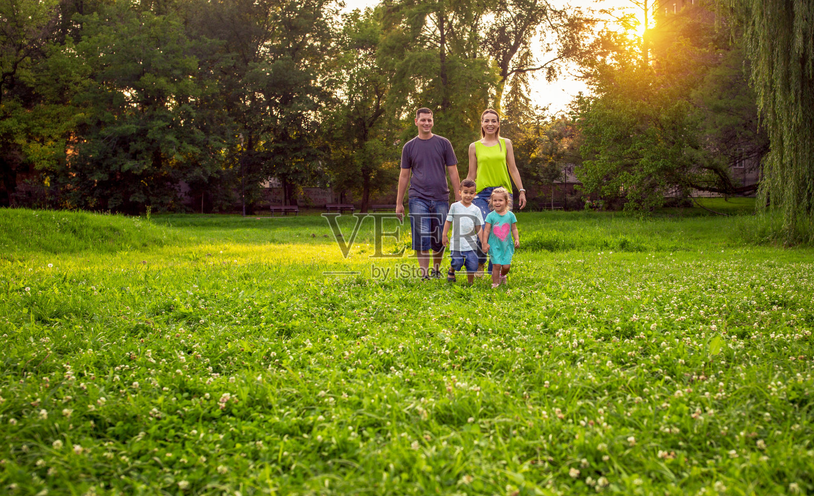 欢乐时光：年轻夫妇与孩子在美丽的户外公园玩耍照片摄影图片