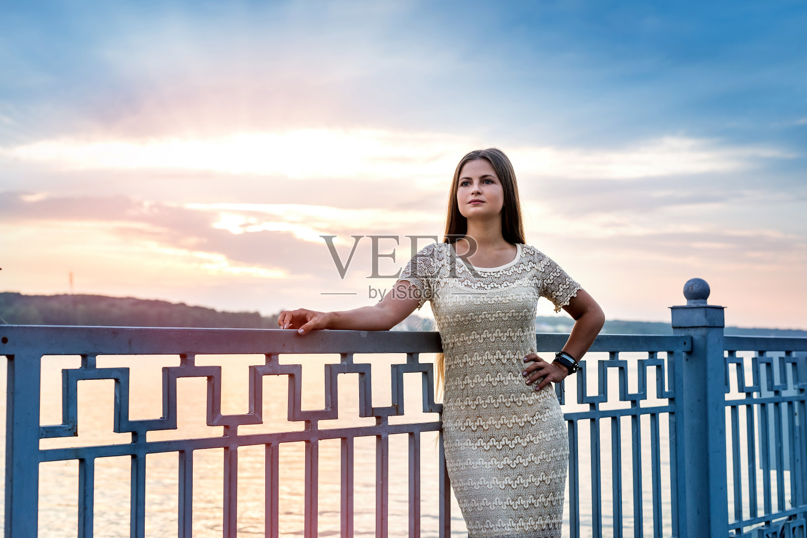 落日余晖下的湖上，年轻美丽的女子照片摄影图片