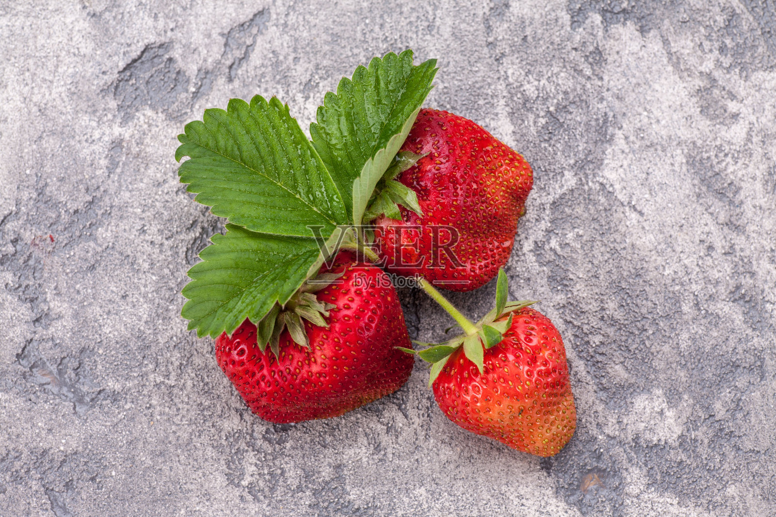 蓝石背景上的草莓，新鲜浆果。照片摄影图片